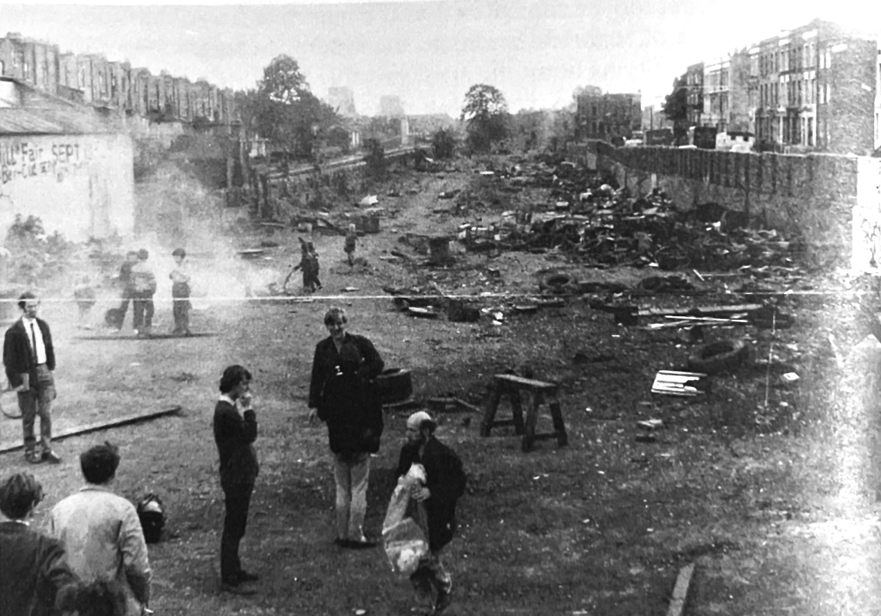 Photo of Gustav Metzger amongst trash and smoke.